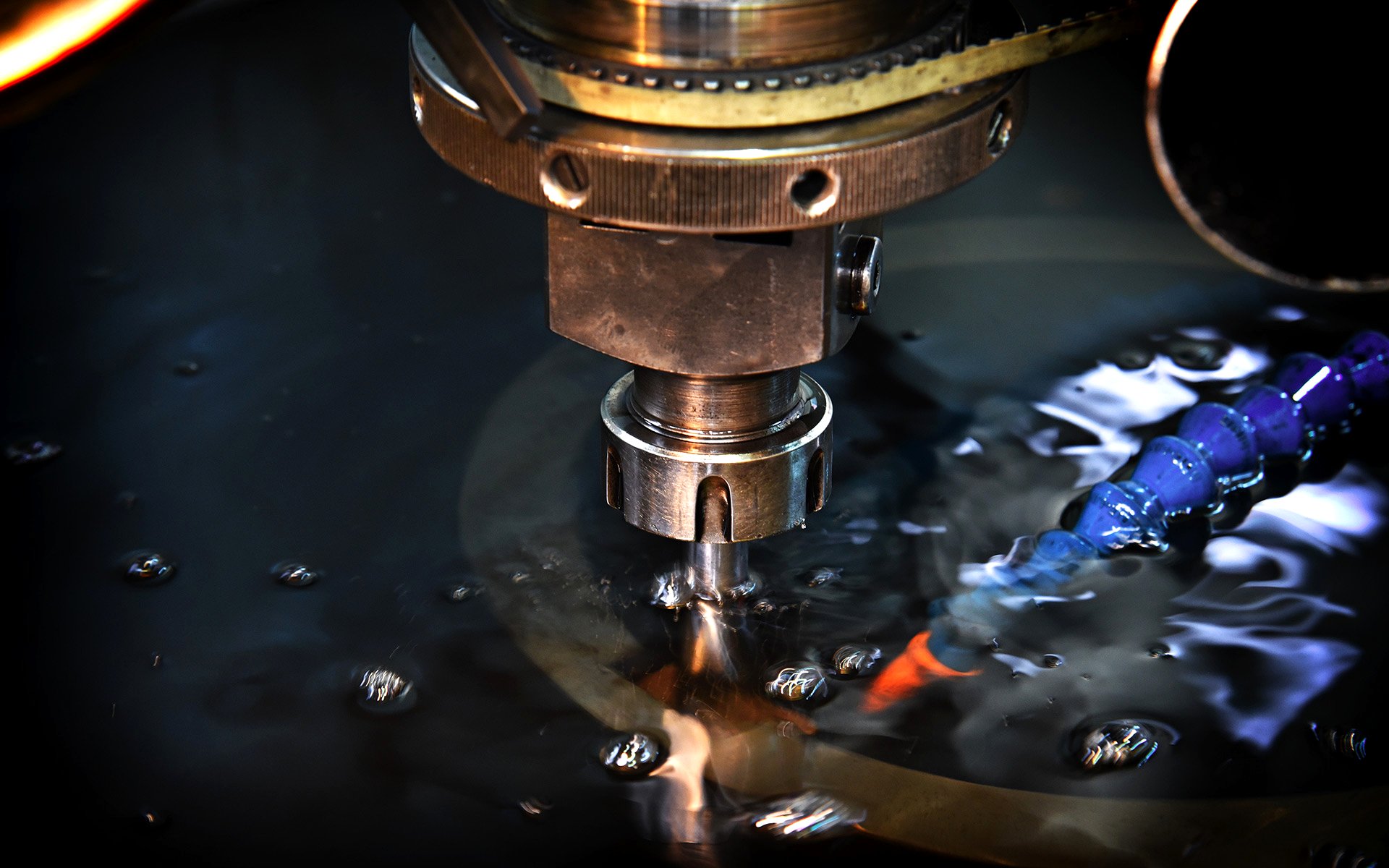 Sinker EDM electrode submerged in dielectric fluid, spark erosion visible